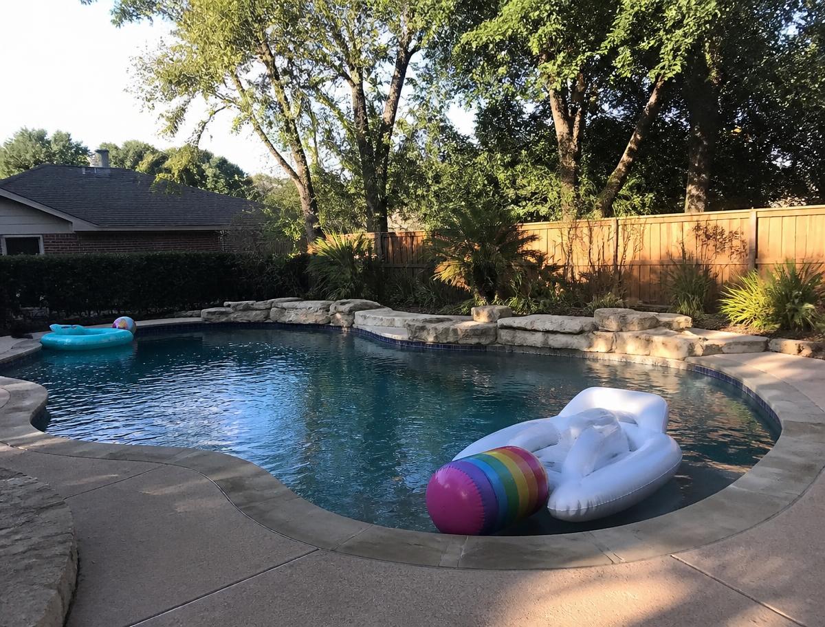 Freeform backyard pool with mature trees in Lakewood