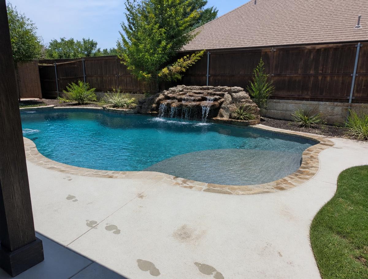 Dallas backyard pool with a stone waterfall